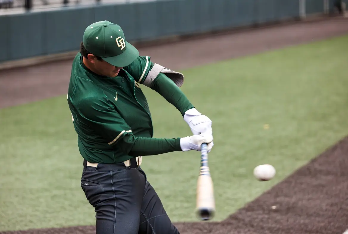 College baseball batter mid-swing at home plate